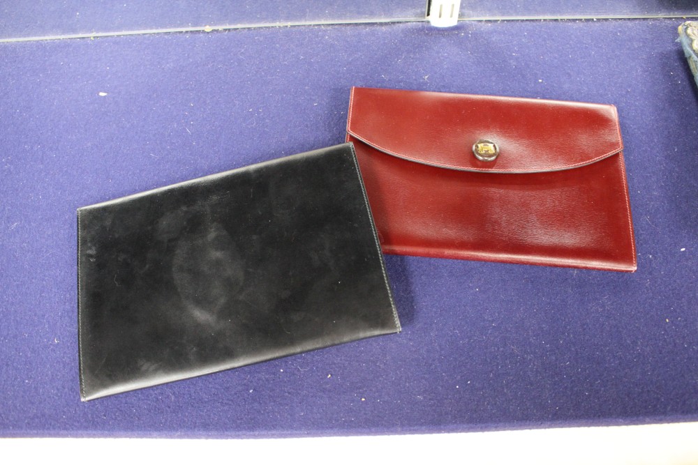 Two Hermes leather clutch purses, one in black, the other burgundy, 24 x 16.5cm, with one Hermes orange card box